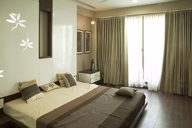 Apollo DB City – bedroom with floor-to-ceiling curtained windows in the sample flat