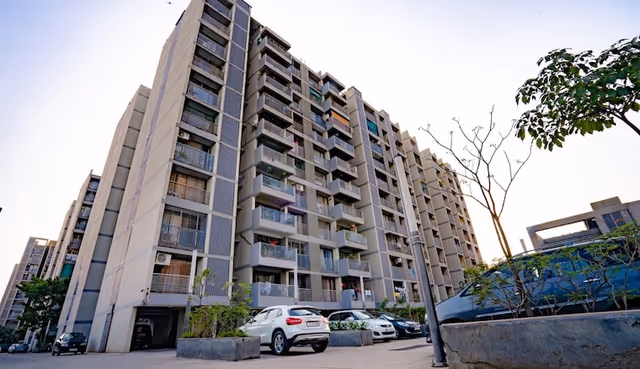 Apollo DB City – street-level view of an occupied tower with resident parking