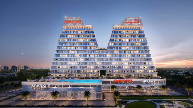 Sparklz by Danube – front elevation at dusk with the podium-level pool deck lit up